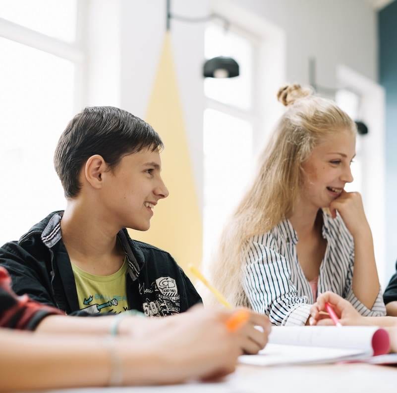 11 plus students sitting round the table and studying in Surrey.